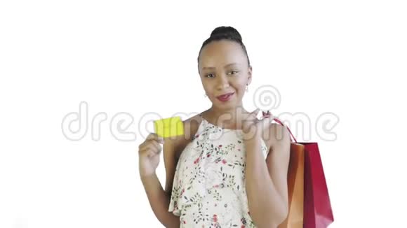 手里拿着信用卡和包裹的非裔美国妇女白色背景带花的白色连衣裙视频的预览图