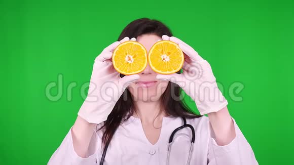 年轻女医生的肖像营养学家穿着白色的医疗制服用听诊器拿着两半视频的预览图