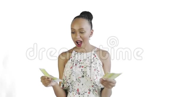 一位迷人的美国黑人妇女正在用白色背景数钱带花的白色连衣裙视频的预览图