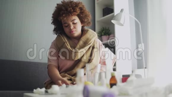 生病的非洲裔美国流感女孩躺在家里的沙发上病了的年轻黑人妇女用感冒检查体温视频的预览图