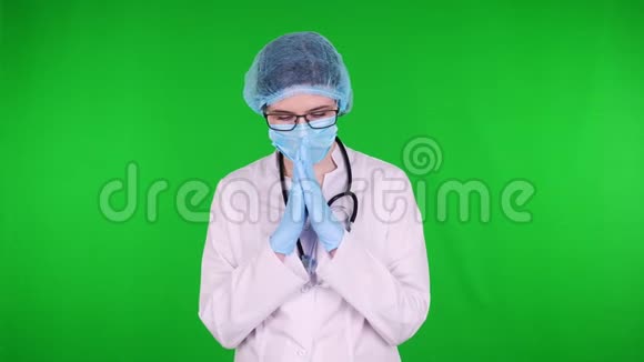 戴眼镜的女祈祷医生画像身穿白色医疗制服带听诊器戴蓝色医疗面具视频的预览图