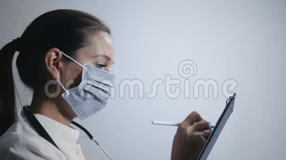 女性医生在医疗面具上做笔记视频的预览图