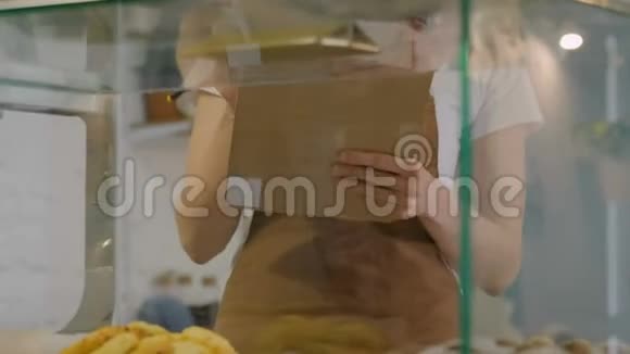 在面包店窗口点糕点的女人视频的预览图