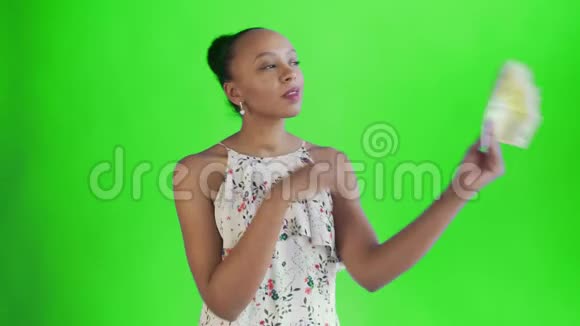 体贴成功的非洲裔美国妇女绿色背景有钱带花的白色连衣裙视频的预览图