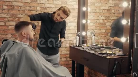 理发师在沙龙刮胡子和理发后从男性脸上扫茬为有胡子的客户服务的男理发师视频的预览图