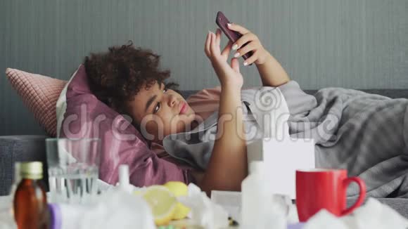 生病的非裔美国少女用电话和手帕吹鼻子视频的预览图