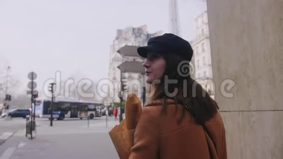 镜头跟随美丽的快乐美食博主女人走在巴黎大街上带着购物袋慢动作视频的预览图