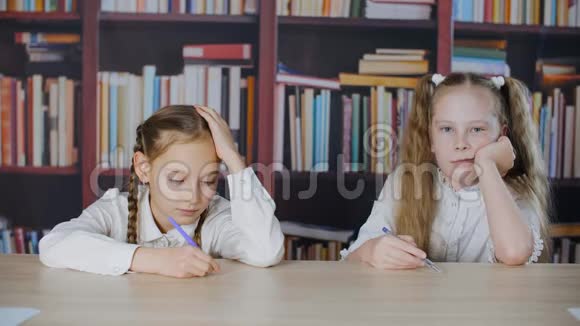 书架背景上微笑的女学生在学校考试中解题快乐同学作文考试视频的预览图