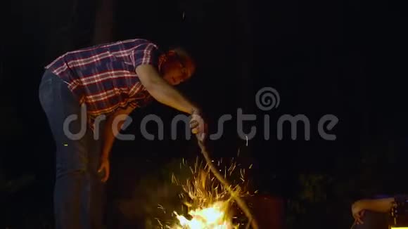 人拿着木头晚上燃烧着篝火视频的预览图