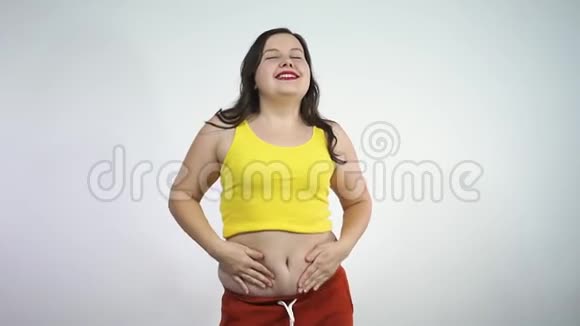 超重的年轻女人扭动着肚子微笑着身体正面概念视频的预览图