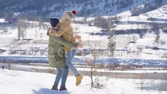 一对年轻漂亮的夫妇在一个阳光明媚的日子里在雪山上玩得很开心寒假概念视频的预览图