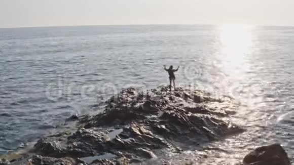 在海角悬崖海岸上跳舞的女孩的空中摄影视频的预览图