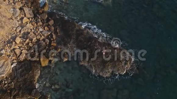 在海角悬崖海岸上跳舞的女孩的空中摄影视频的预览图