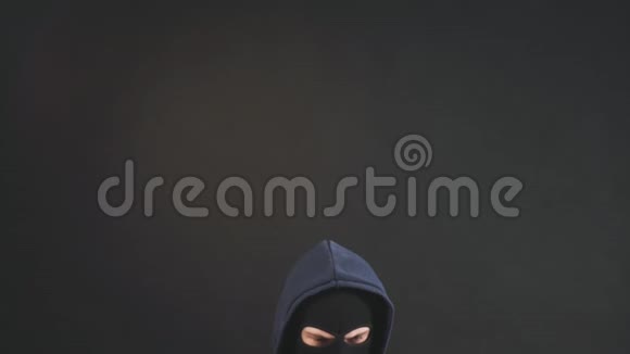 一个戴着黑色面具和帽子的男性黑客用笔记本电脑来入侵硬盘视频的预览图