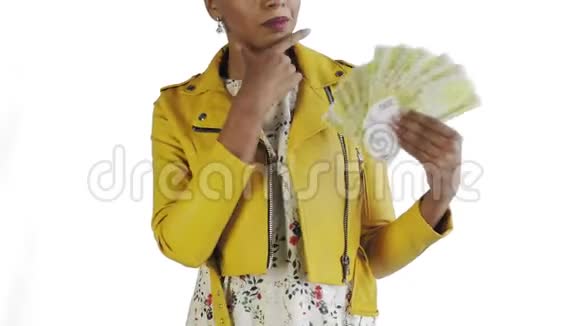 体贴成功的非洲裔美国妇女与金钱粉丝在白色背景工作室黄色夹克视频的预览图