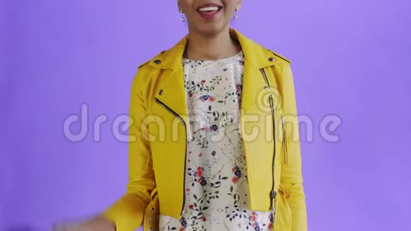 心满意足的非洲裔美国女人穿着紫底黄夹克露出大拇指视频的预览图
