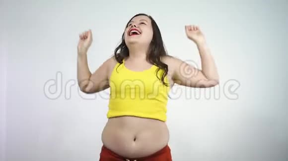 身体健康一个大肚皮的胖女孩兴奋地跳着舞微笑着视频的预览图