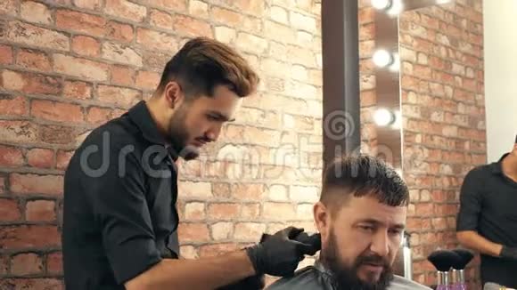 理发店的年轻理发师给留胡子的英俊客户理发视频的预览图