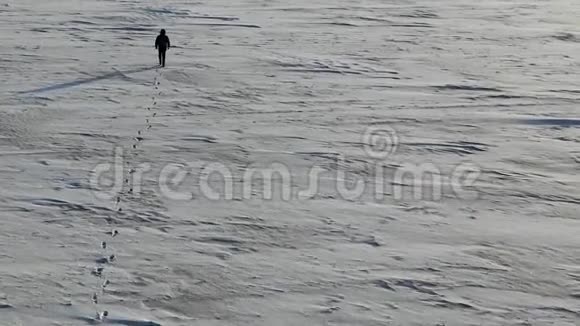 孤独的人走过一片雪白的沙漠空中视角视频的预览图