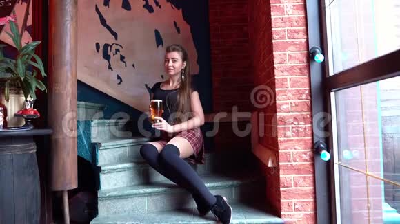 坐在台阶上喝着玻璃啤酒的女孩视频的预览图