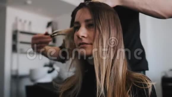 理发师的特写梳理客户头发年轻的白种人女孩视频的预览图