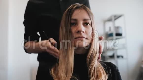理发师的特写梳理客户头发年轻的白种人女孩视频的预览图