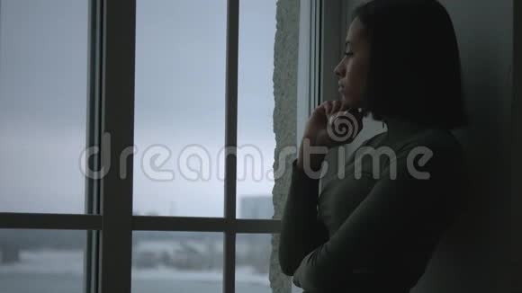 沮丧沮丧的女人靠在窗户上视频的预览图