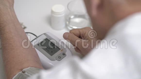 老人在餐桌上使用数字血压监测仪视频的预览图