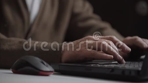 老人坐在笔记本电脑旁和朋友聊天打字视频的预览图