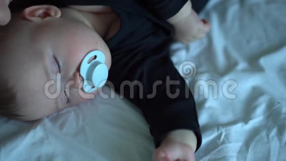 穿着黑衣服的孩子嘴里放着奶嘴睡觉视频的预览图