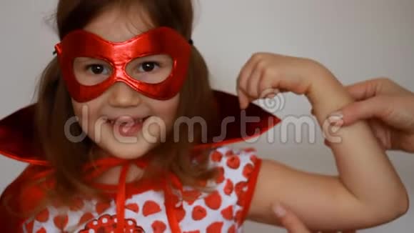 小女孩扮演超级英雄有趣的孩子穿着红色雨衣和面具玩权力超级英雄超级英雄和权力概念视频的预览图