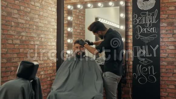 发型师给理发店的帅哥客户理发视频的预览图