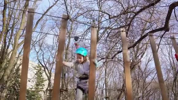 小女孩试图爬上绳索公园视频的预览图