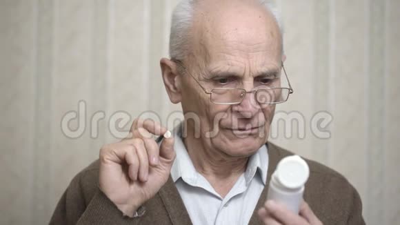 戴眼镜的老人在房间里看药瓶视频的预览图