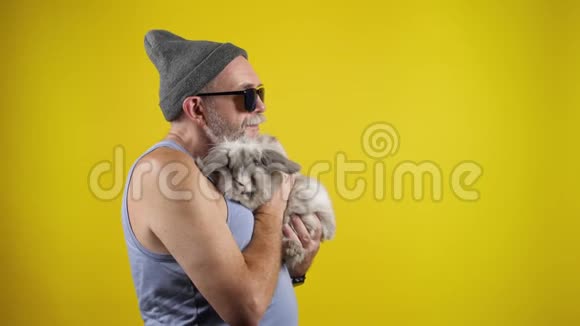 年老时尚的男人抱着灰色的兔子视频的预览图