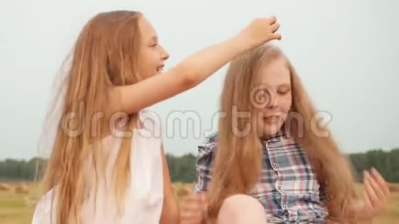 女孩触摸女性朋友户外的头发视频的预览图