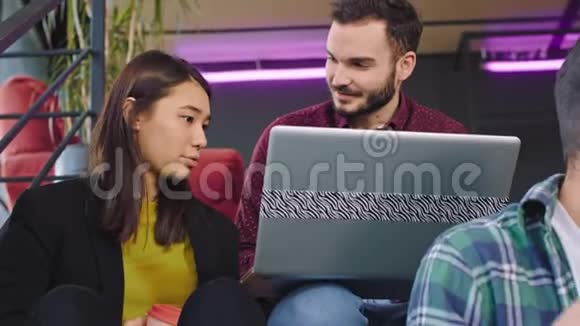一位漂亮的女士一头金发一个长着下巴的帅哥坐着在笔记本和平板电脑上工作视频的预览图