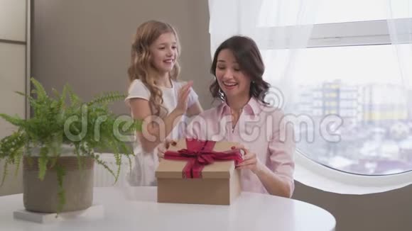 小女孩一边亲吻一边拥抱妈妈一边送礼物盒视频的预览图