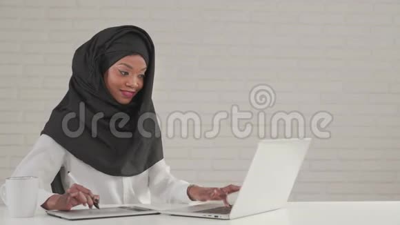 在数码平板电脑和笔记本电脑上工作的女人视频的预览图