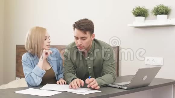 已婚夫妇在家审计时使用笔记本电脑视频的预览图