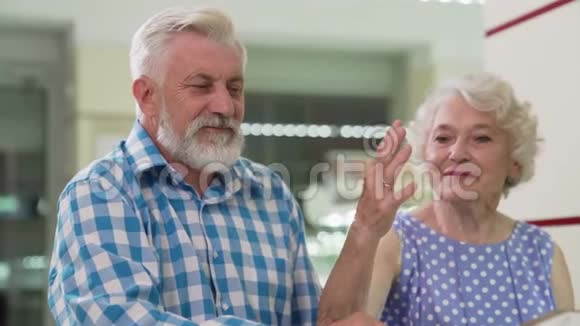 一位穿着时髦衣服的老年女士在珠宝店试穿新戒指视频的预览图