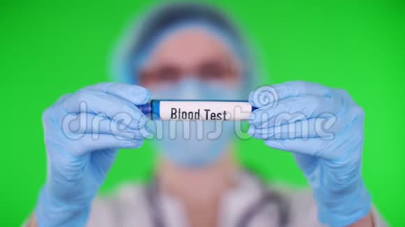 绿色背景特写医生双手戴蓝色医用手套用铭文验血试管医生视频的预览图