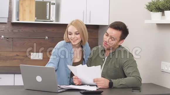 美丽的年轻丈夫与微笑的幸福妻子讨论合同细节的财务问题视频的预览图