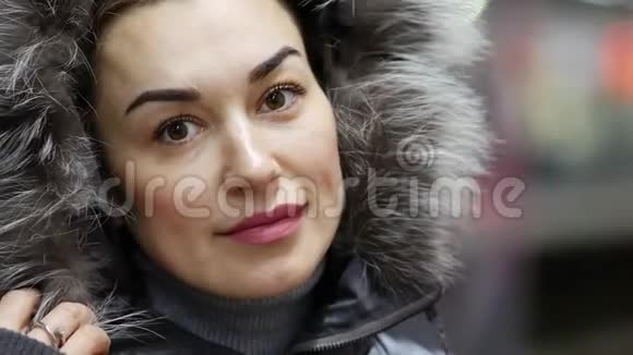 美丽的女士穿着冬季夹克戴着人造毛皮装饰帽站在地铁站台上视频的预览图