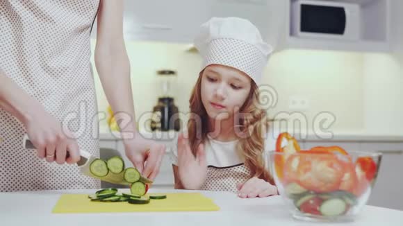 看着她妈妈做新鲜沙拉的漂亮孩子视频的预览图