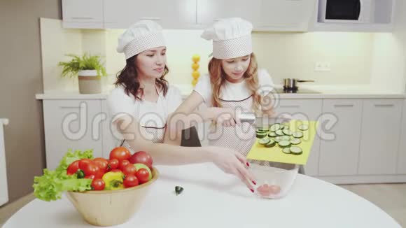 快乐的母女一起做蔬菜沙拉视频的预览图