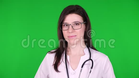 快乐年轻女医生的肖像戴眼镜的外科医生穿着白色的医疗制服和听诊器关于视频的预览图
