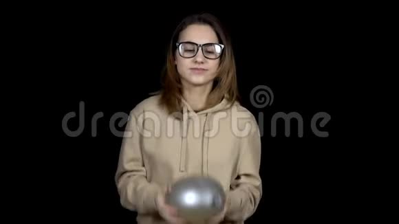 一个年轻的女人用水扔球女孩在黑色背景上摇动球气球像果冻一样颤抖视频的预览图