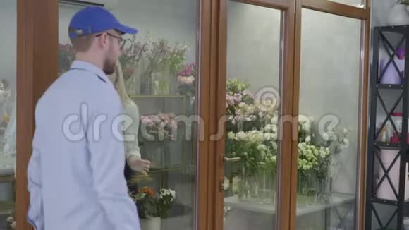 小生意一个在花店工作的小女孩从送花的过程中送给一个男人一束美丽的鲜花视频的预览图