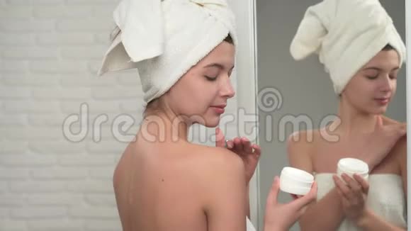 女人拿毛巾把奶油放在肩膀上视频的预览图